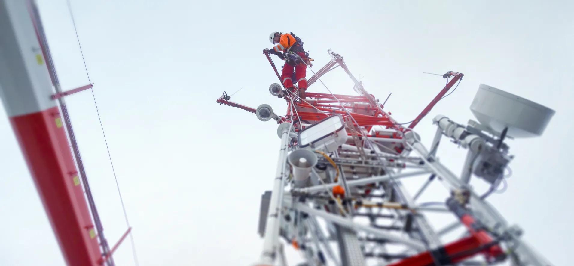 Ein Mitarbeiter bei der Arbeit auf einem Mast