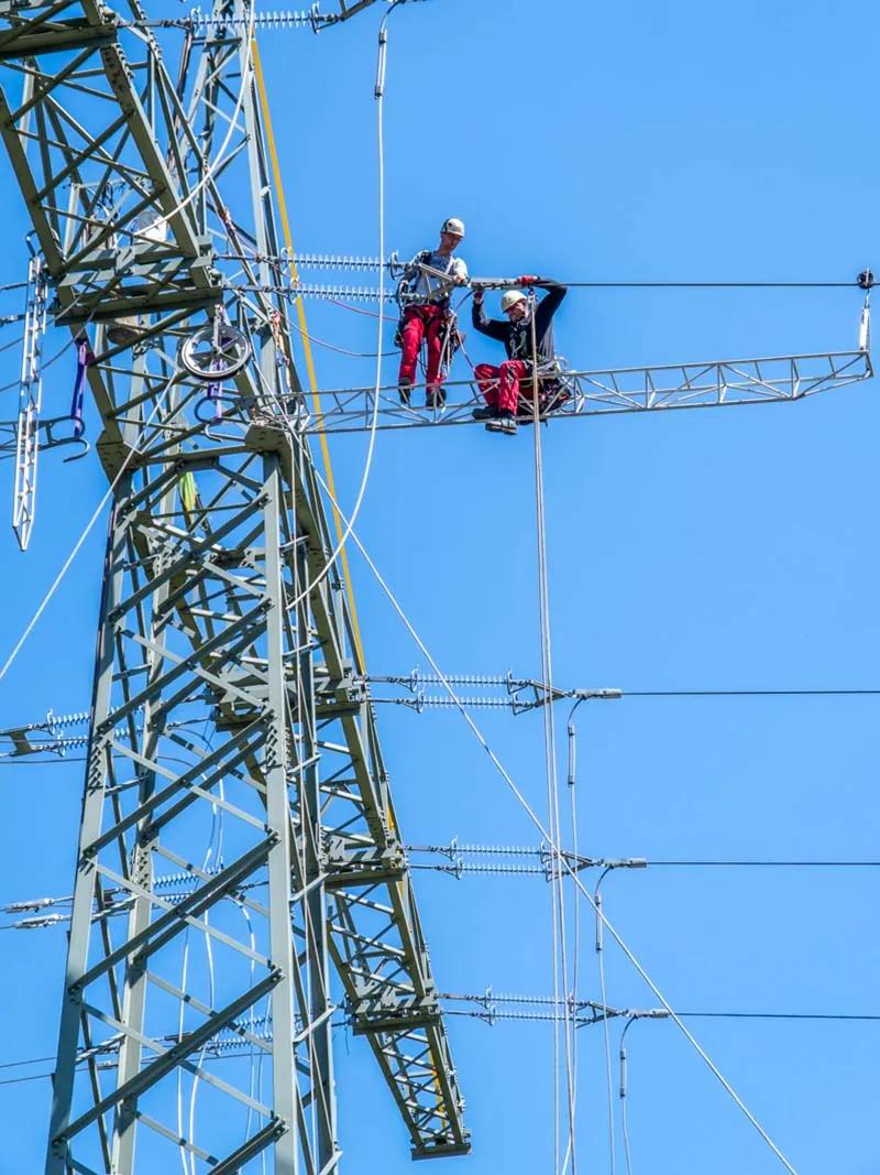 Mitarbeiter bei der Arbeit an einem Freileitungsmast