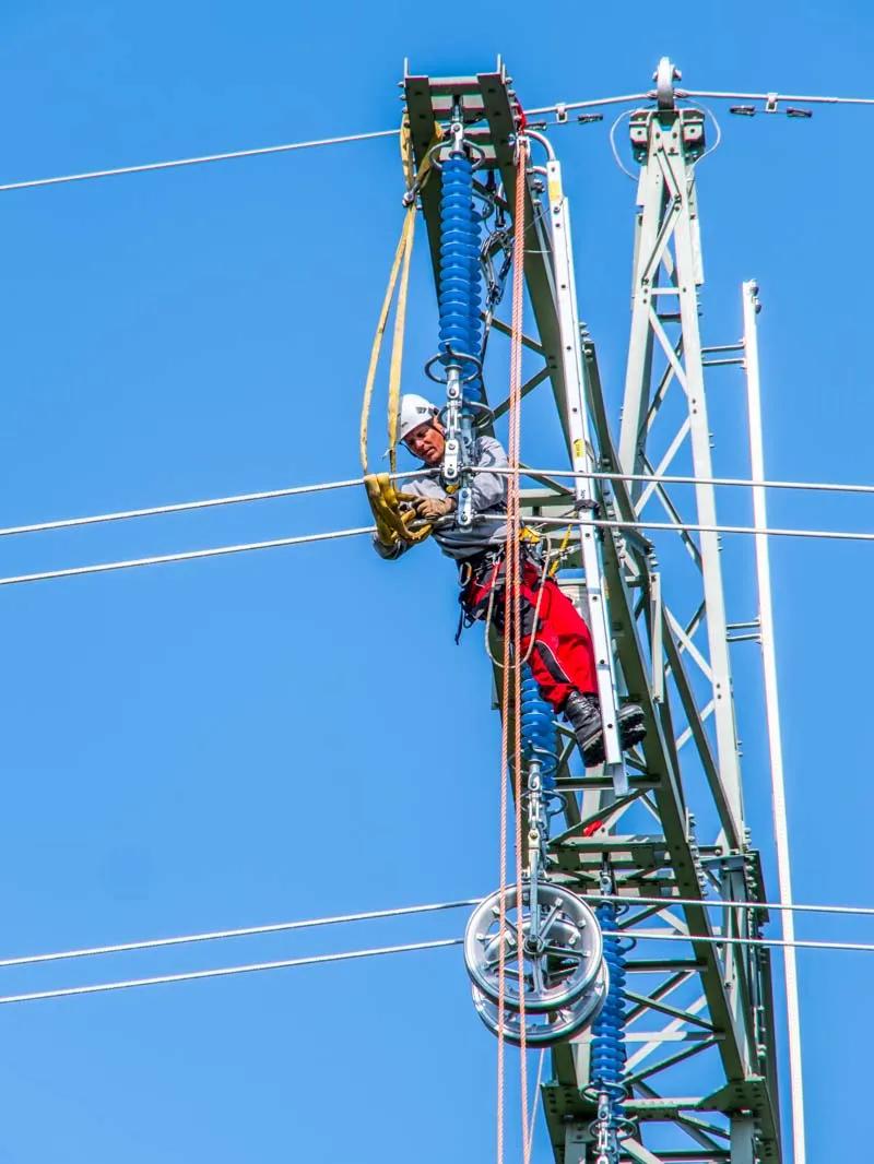 Mitarbeiter bei der Arbeit an einem Freileitungsmast