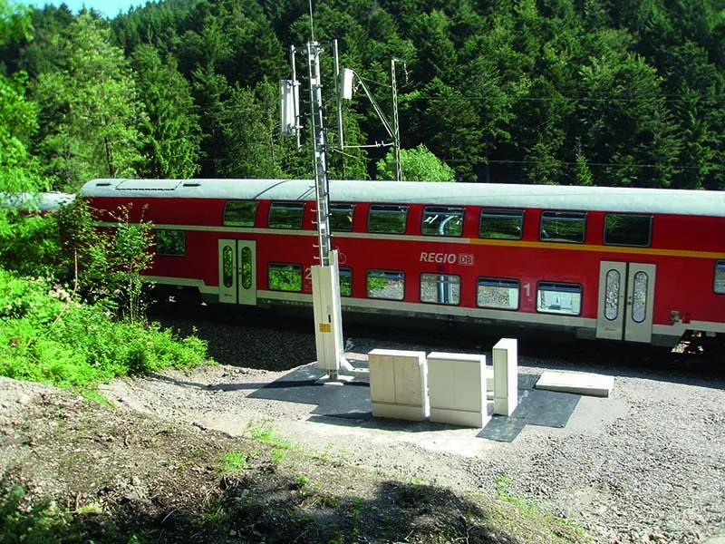 Mast und Schaltschränke vor einem Zug