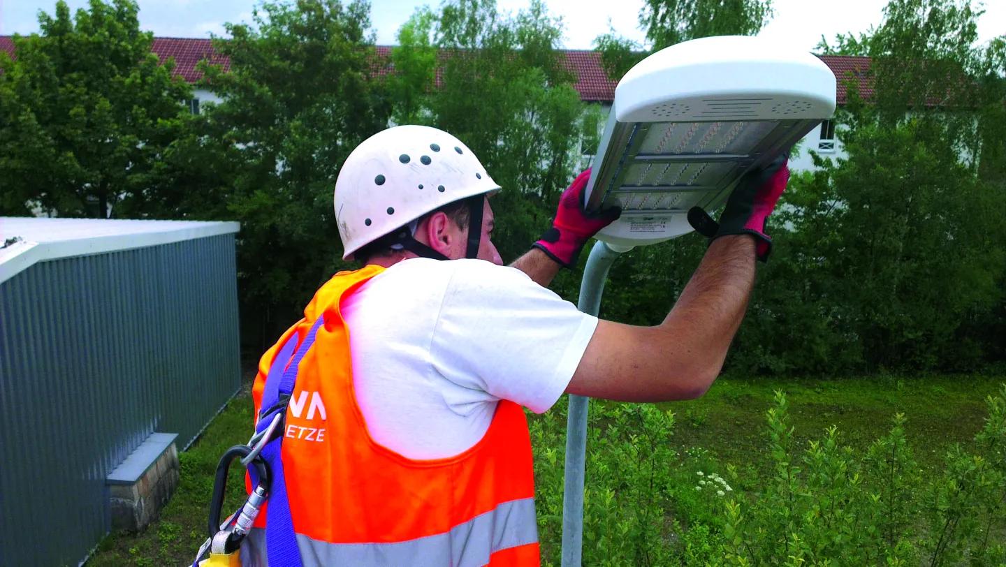 ein Mitarbeiter bei der Arbeit an einer Straßenbeleuchtung