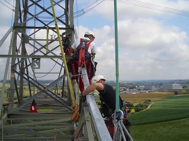 Mitarbeiter bei der Arbeit an einem Freileitungsmast