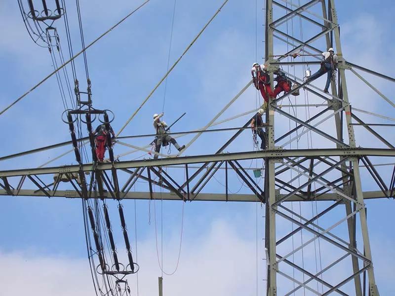 Mitarbeiter bei der Arbeit an einem Freileitungsmast