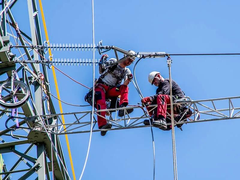 Mitarbeiter bei der Arbeit an einem Freileitungsmast